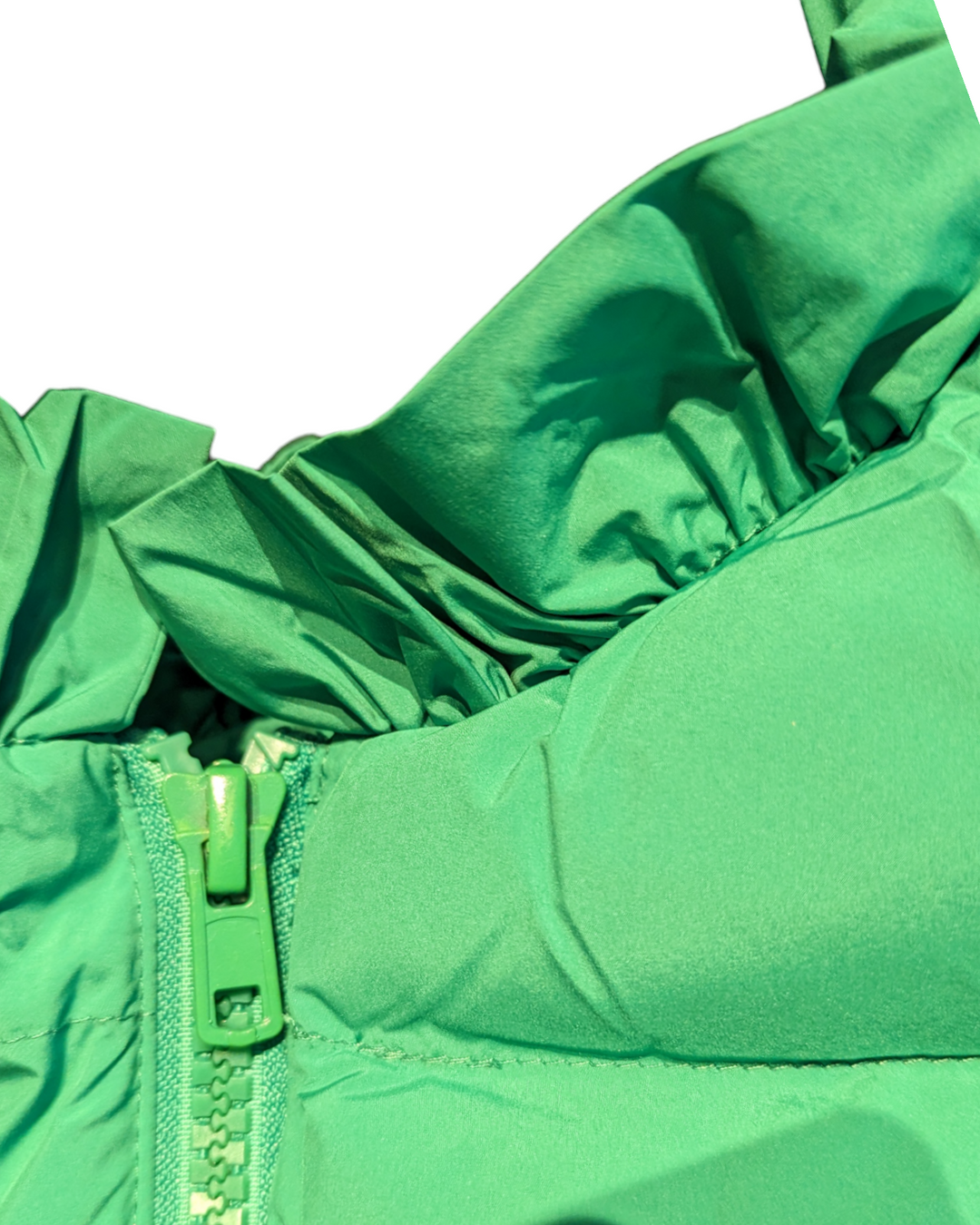 detail view of the zipper closure and ruffle on the neckline of the puffer vest