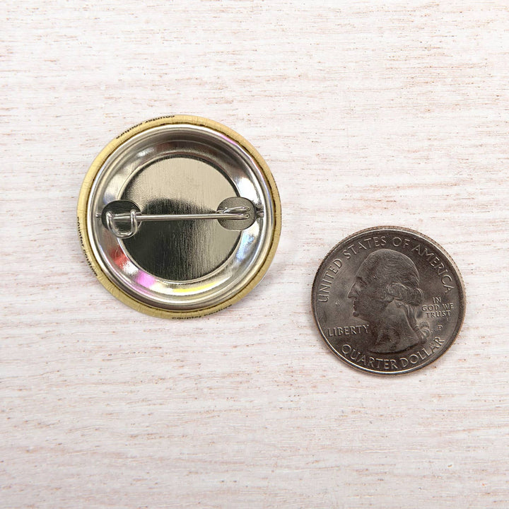 a comparison shot of the back of the bison button next to a quarter. why?