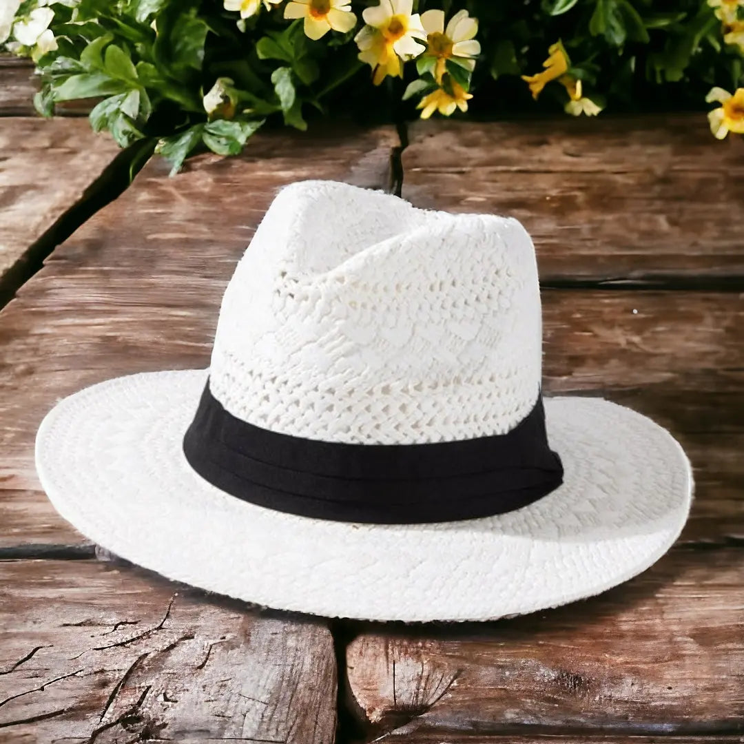 the boho chic panama hat on a wooden surface with flowers in the background