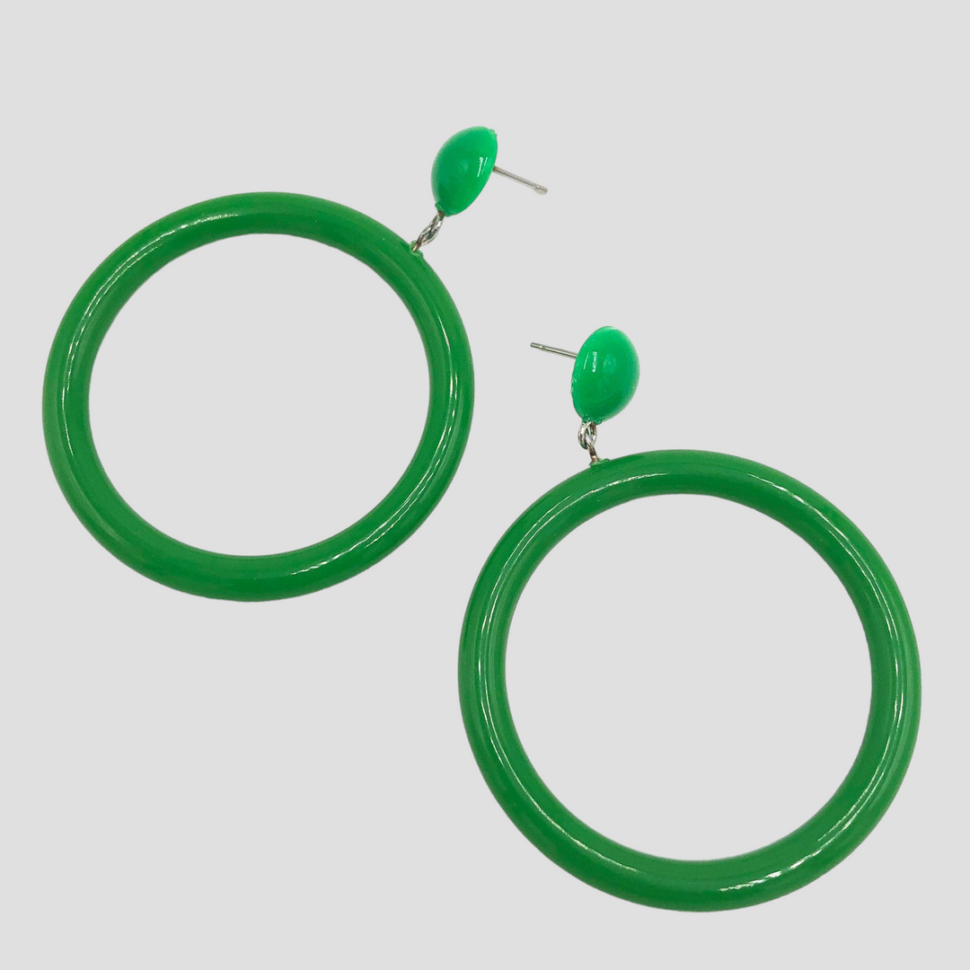 Kelly green button stud hoop earrings laying on grey background