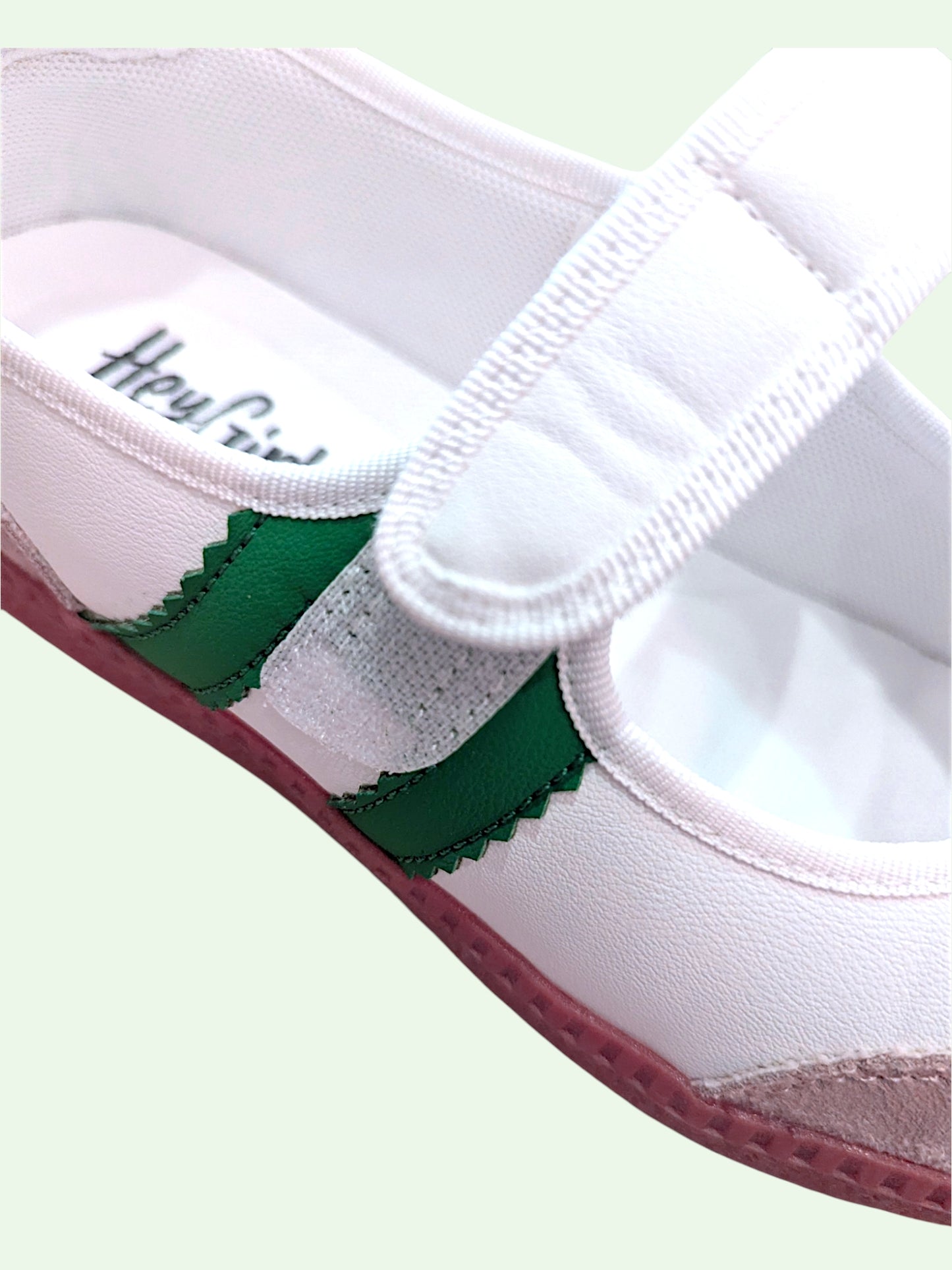 White shoe with green accents on a light green background