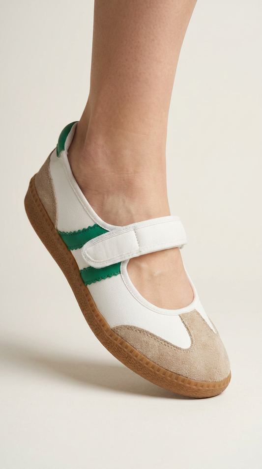 White sandal with green strap on a neutral background