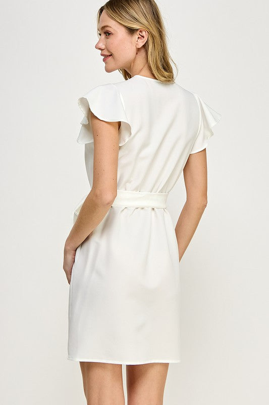 a blonde model shows us the back of the ivory faux wrap dress