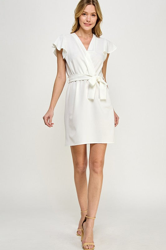 a blonde model shows us the full length view of the faux white wrap dress