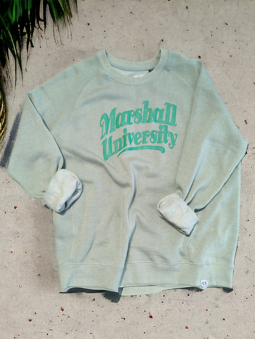 a flatlay of the marshall beachy sweatshirt, looking all cute in some AI sand