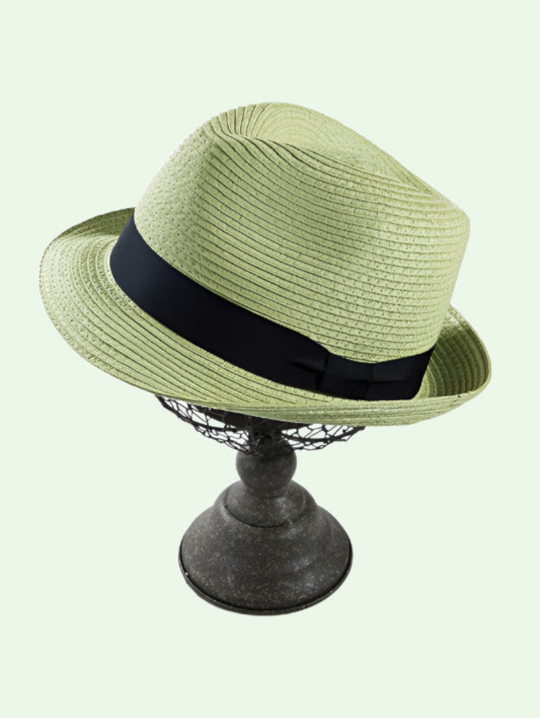 a green hat with a black ribbon on a metal hat stand
