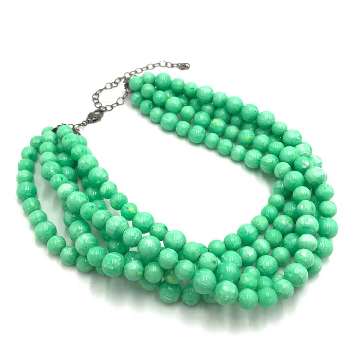 Side view of Green marbled multi-strand beaded necklace on white background