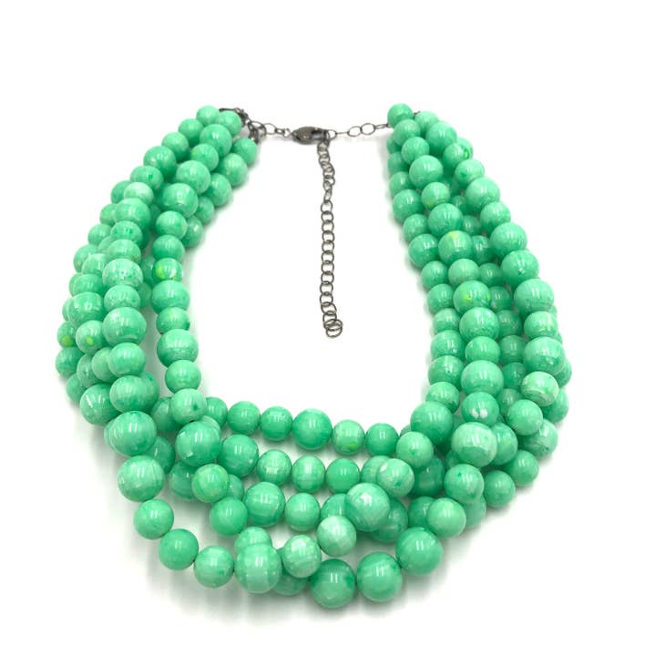 Green marbled multi-strand beaded necklace on white background