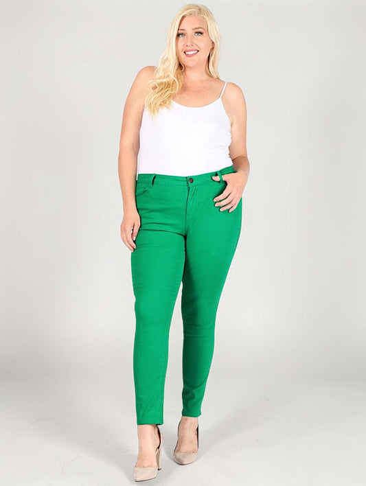 Woman wearing green pants and a white top on a plain background