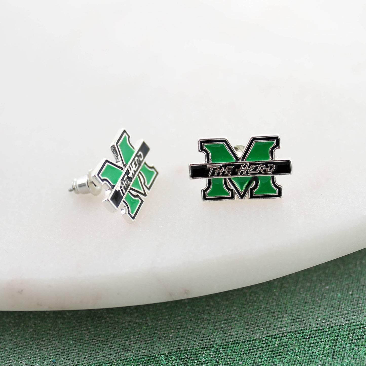 Silver plated stud earrings with green and black enamel featuring the Marshall logo. Laying in white background