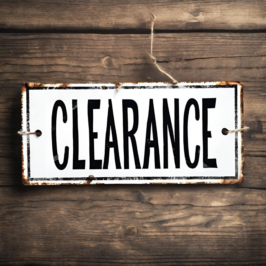 a white sign with black lettering that says clearance hanging on a wooden wall