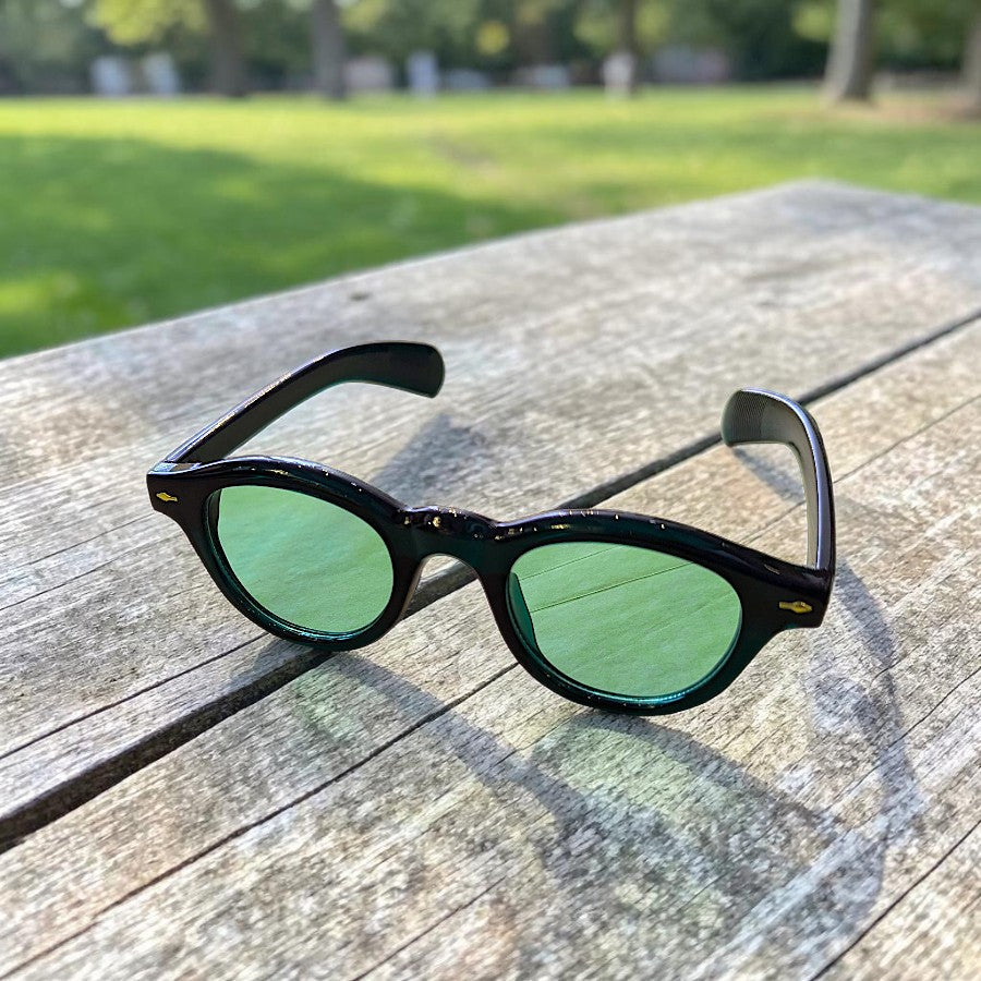 many different pairs of glasses on a wooden table
