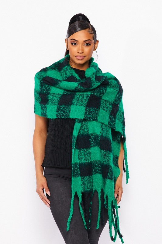 a dark haired model stands with the green plaid scarg wrapped around her shoulders