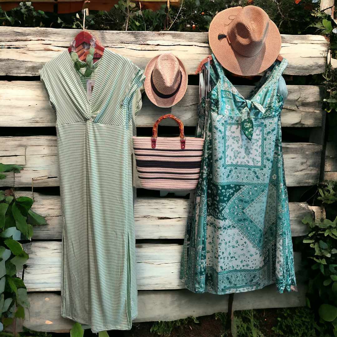 two dresses appear to hang on a rustic white fence,along with some hats and bags.