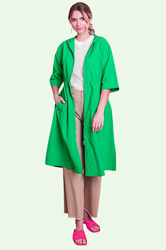 Woman wearing a green coat on a light green background