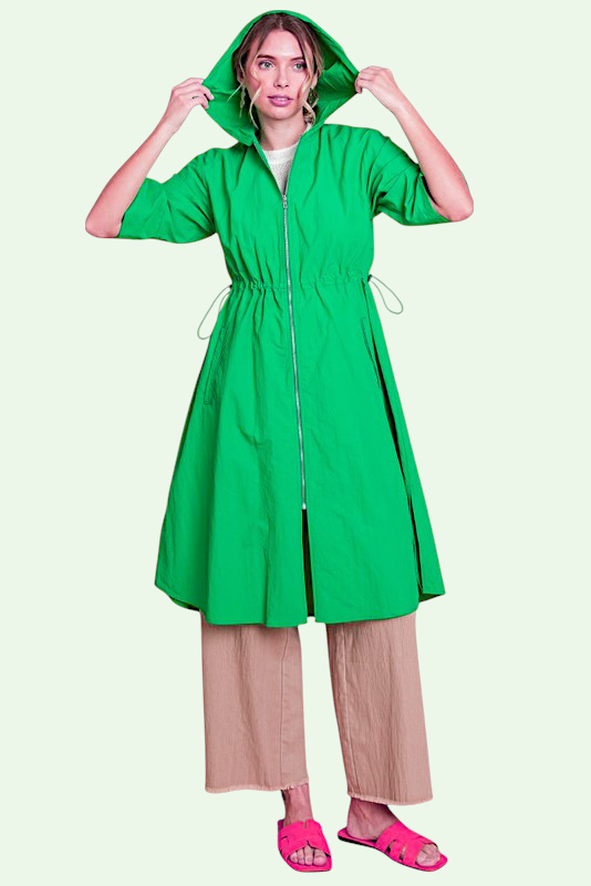 Woman wearing a green raincoat on a white background