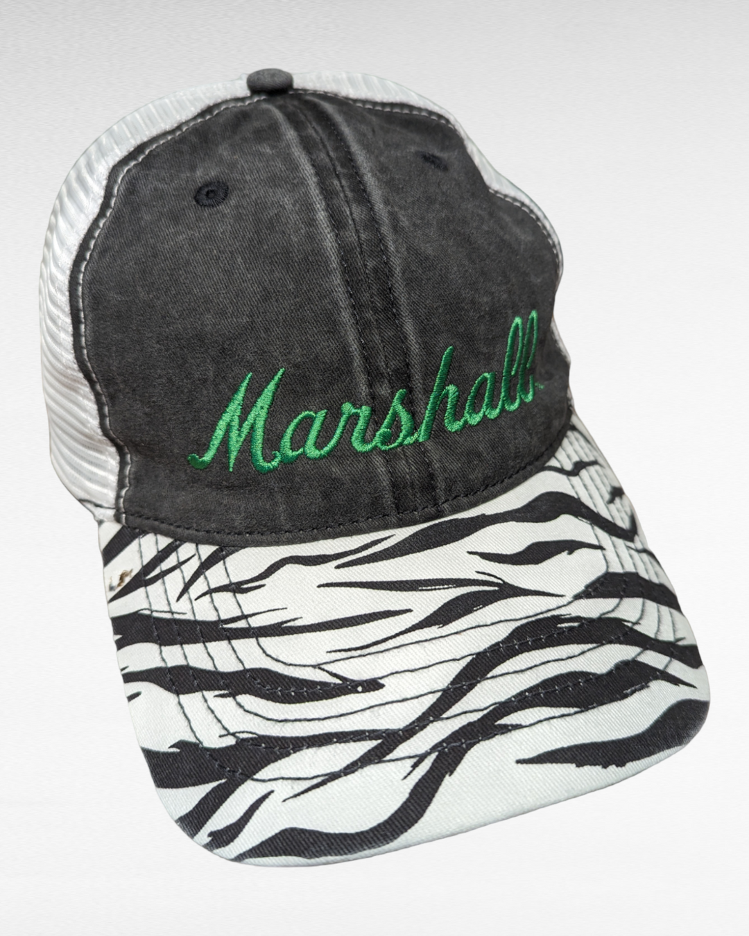 a ballcap with a brim in a zebra pattern with a dark panel on the front that says Marshall in green stitched script