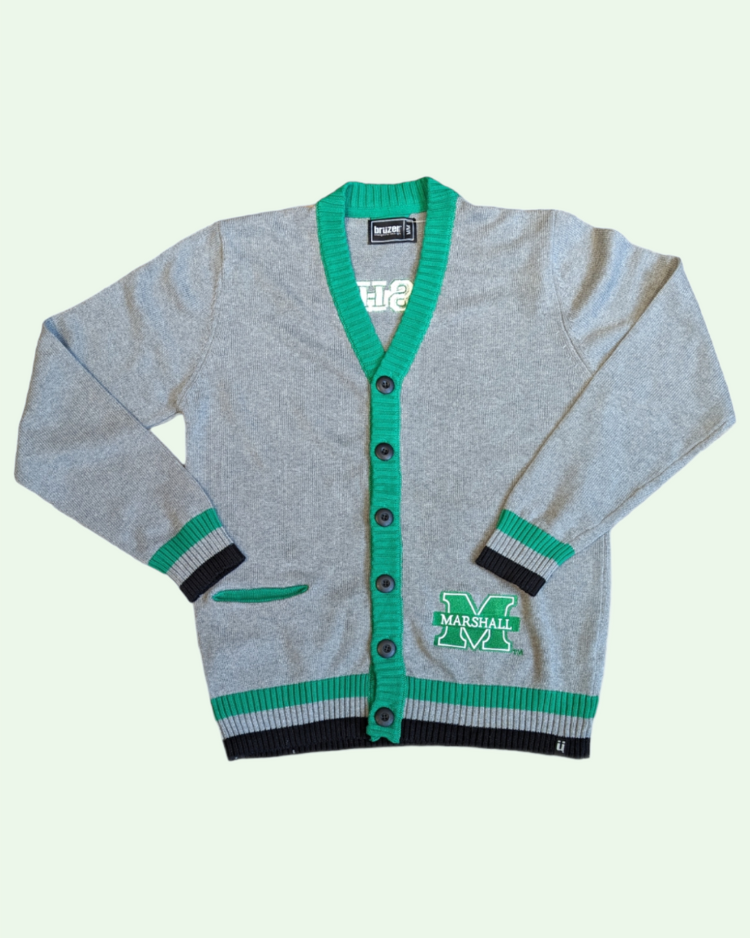 a  grey cardigan trimmed in greenand with green and black stripes at the cuffs and along the bottom. it has a large embroidred marshall m on the front and a small pocket