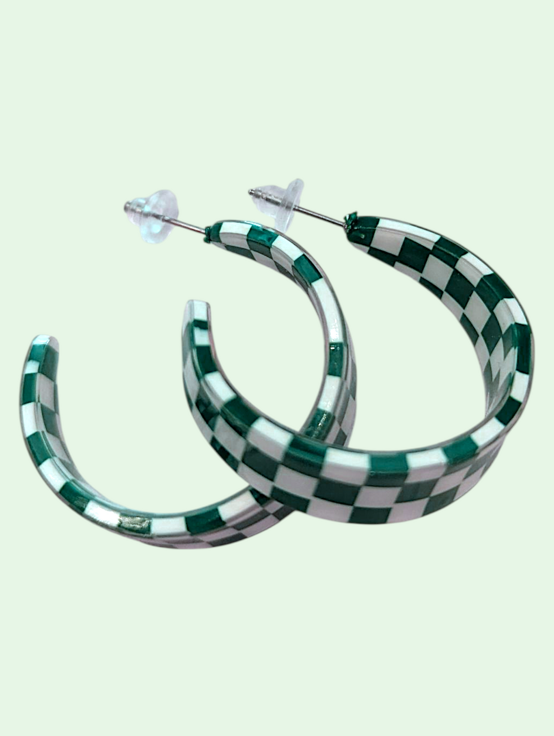 Checkered hoop earrings on a light green background