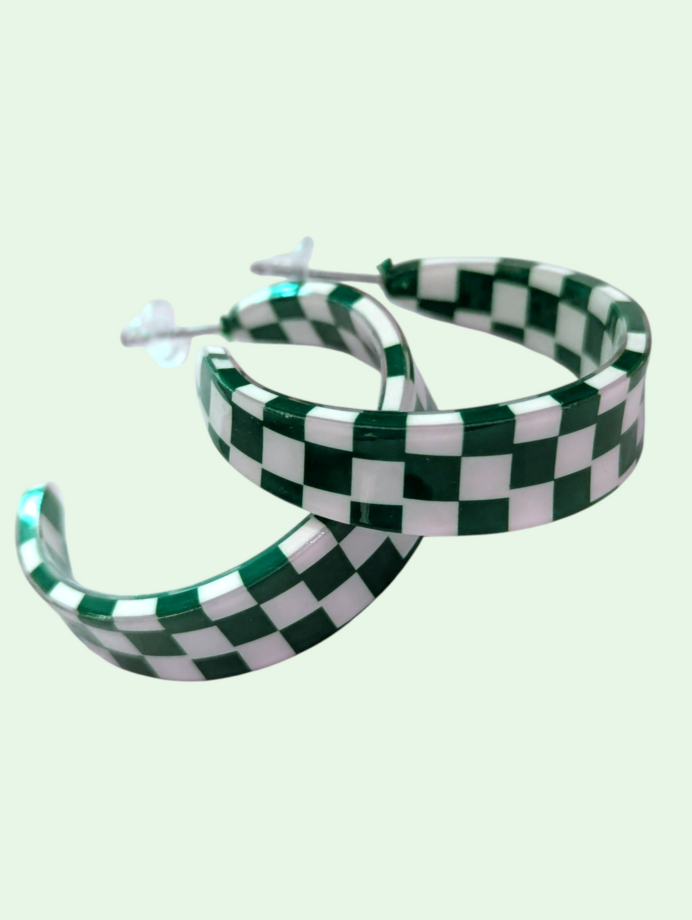 Green and white checkered hoop earrings on a light green background