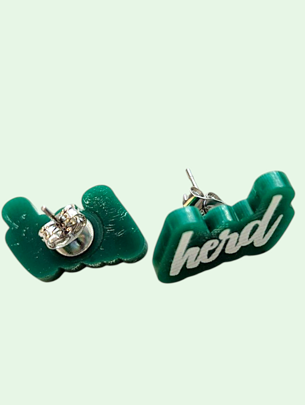 Green earrings with 'herd' text on a light green background