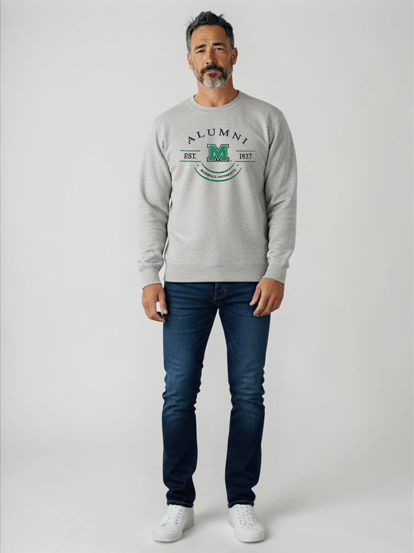 Man wearing a gray sweatshirt with 'Alumni' text and blue jeans on a white background