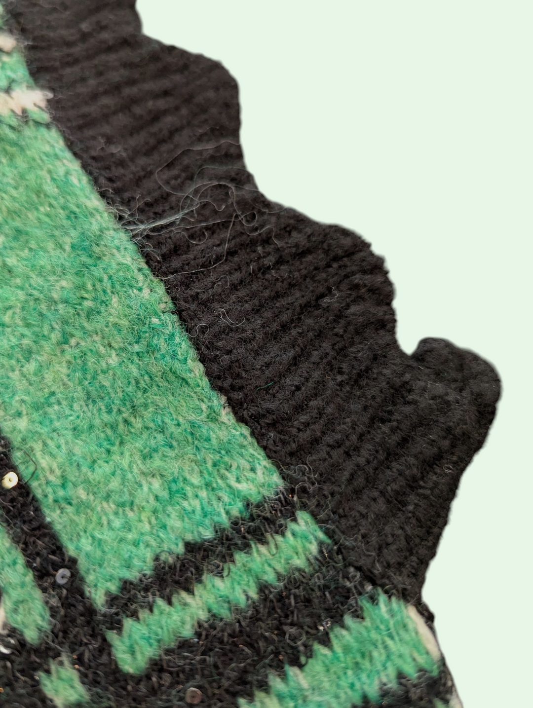 Close-up of green and black textured fabric with a visible seam.