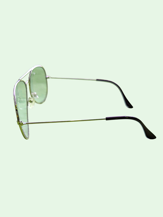 Sunglasses with green lenses and metal frames on a light green background