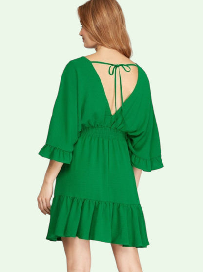 Green dress with ruffled sleeves and hem on a white background