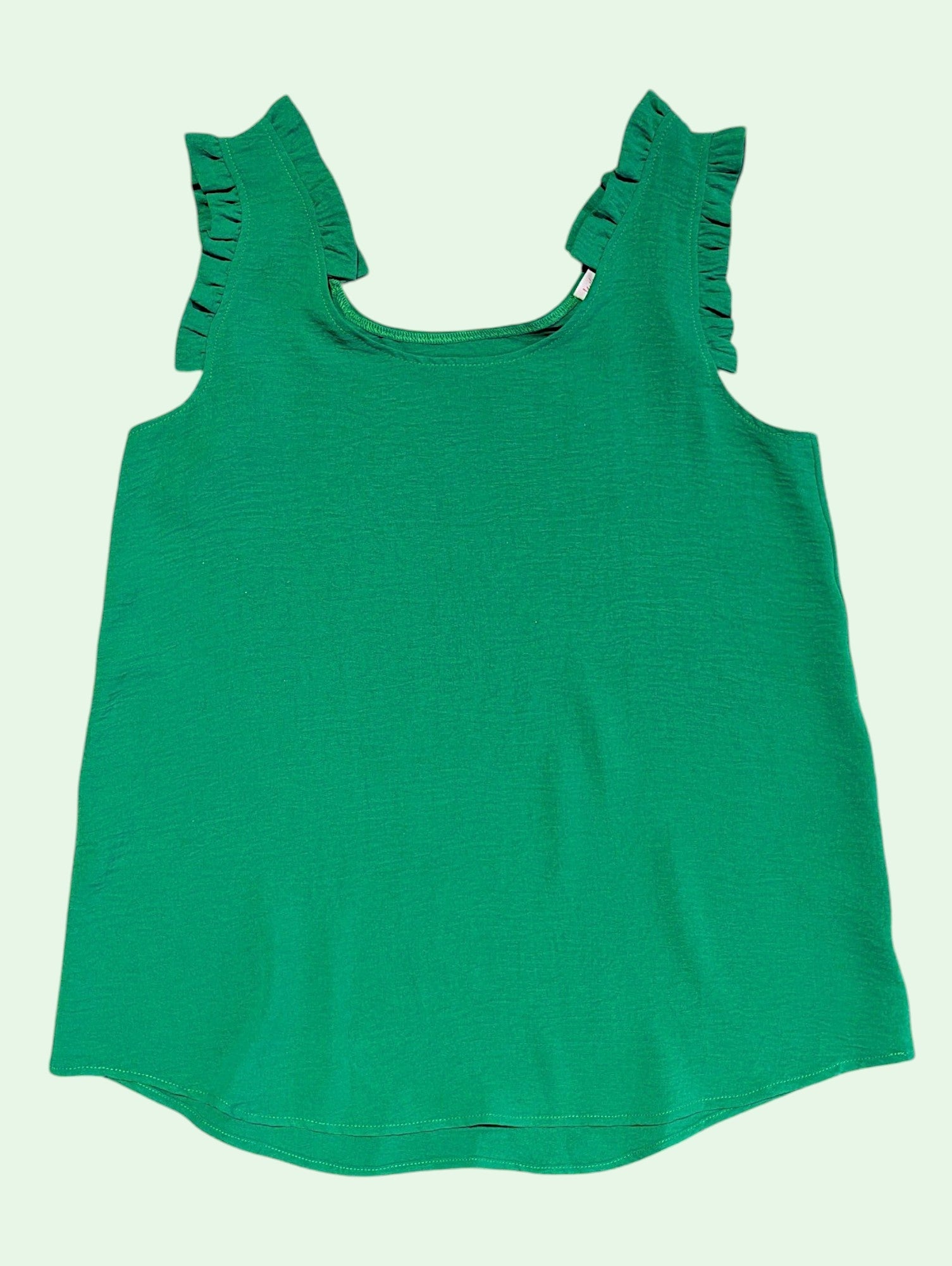 Green tank top with ruffled straps on a light green background
