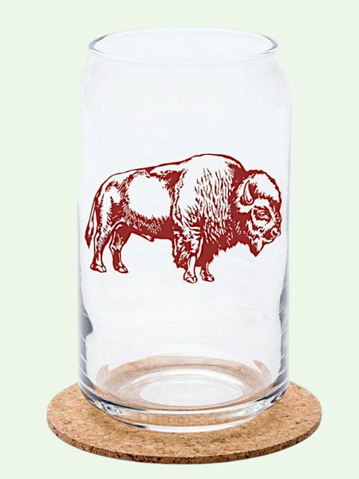 Clear glass tumbler with red bison design on a cork coaster