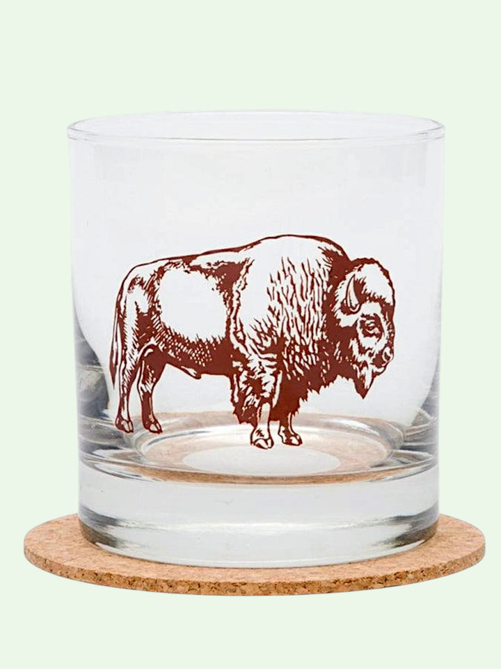 Clear glass tumbler with a red bison design on a white background