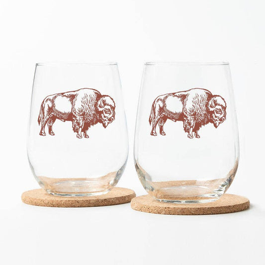Two stemless wine glasses with bison illustrations on cork bases.