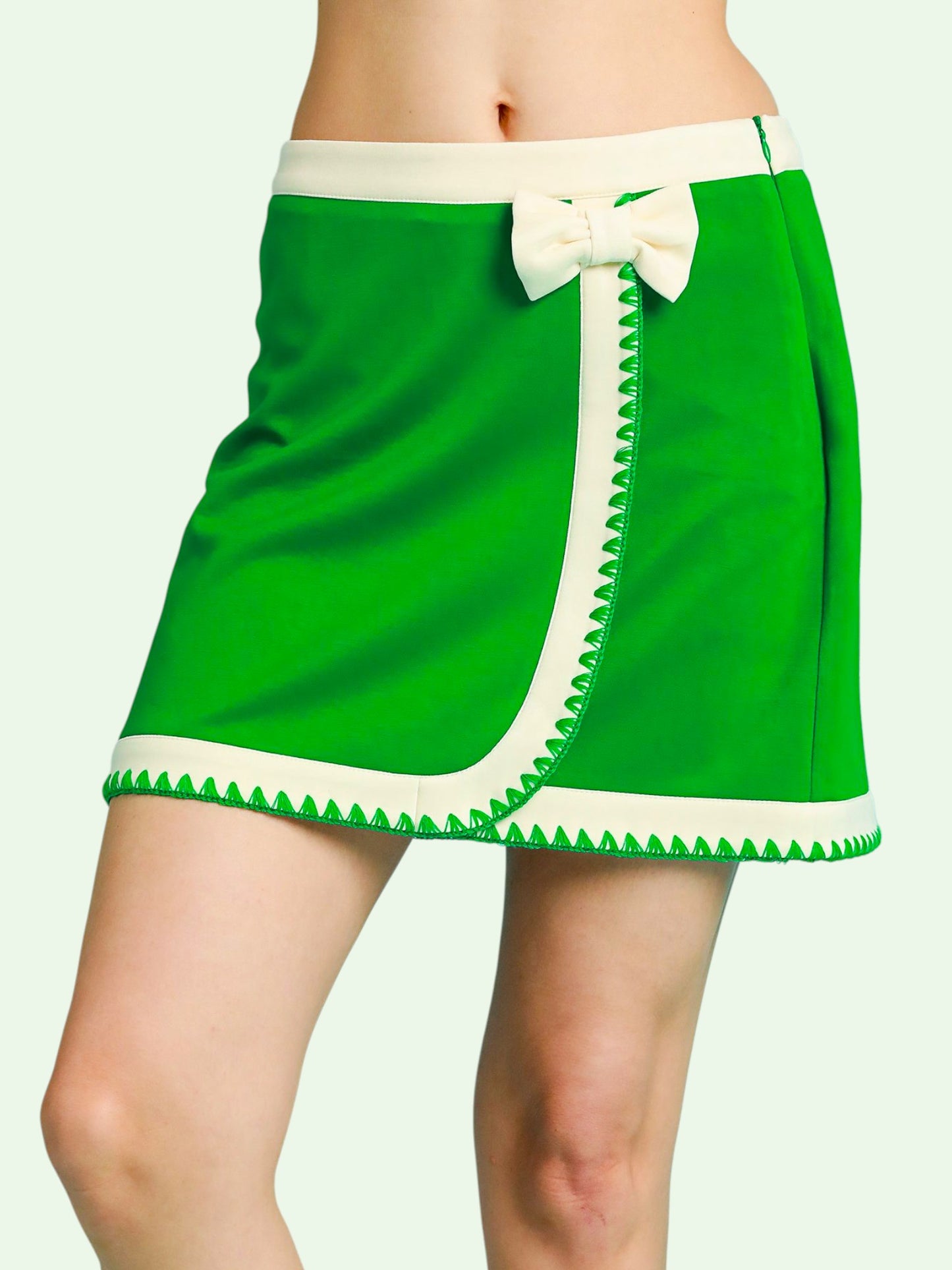 Green skirt with white trim and bow on a plain background