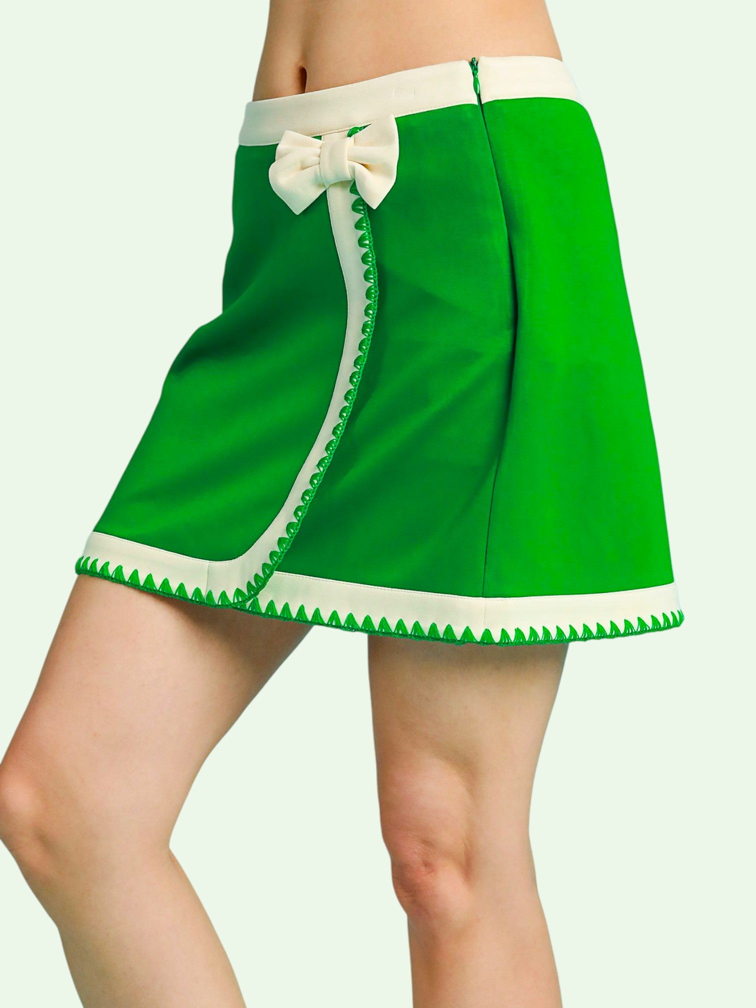 Green skort with white trim and bow on a plain background