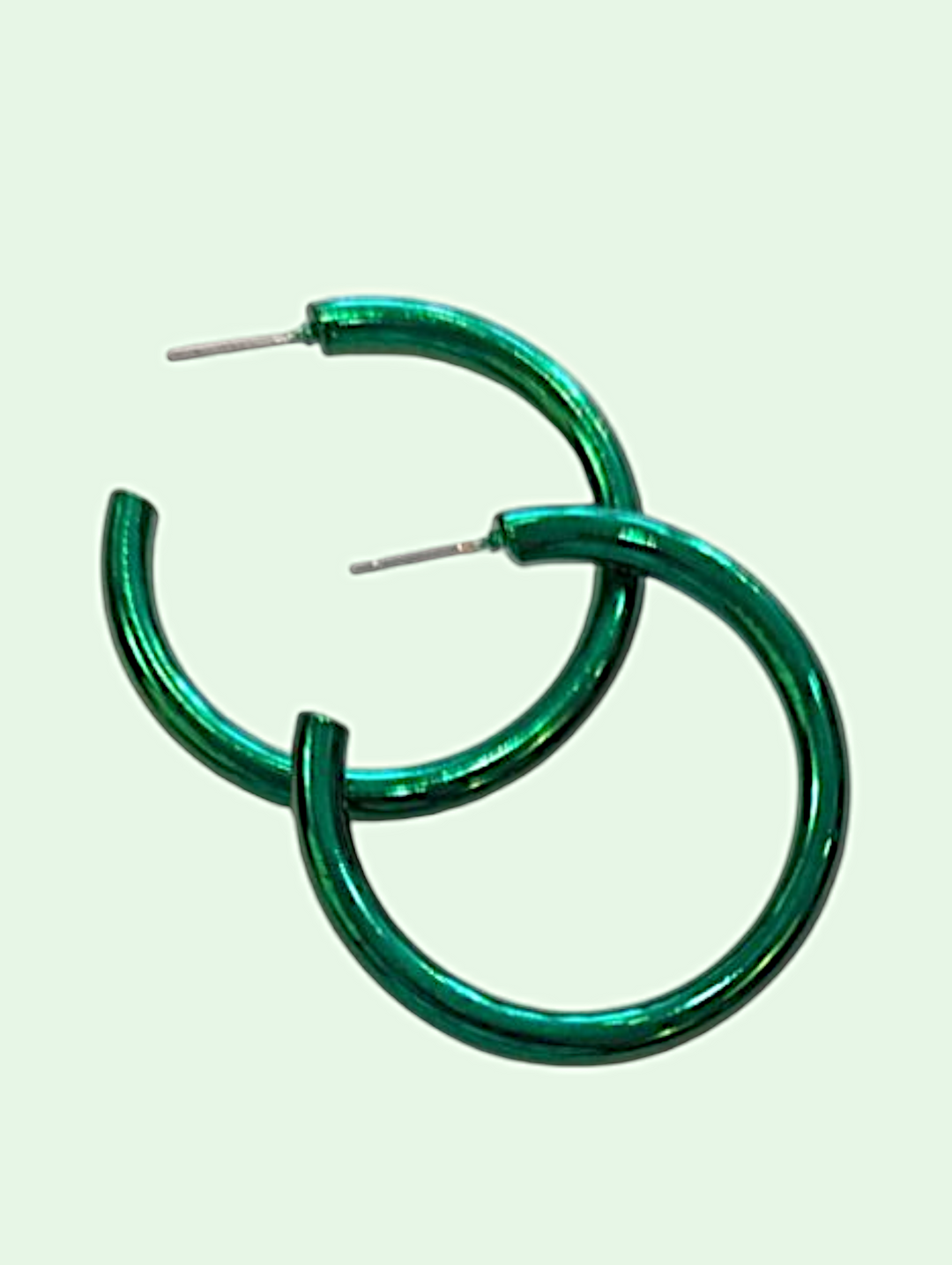 Green hoop earrings on a light green background