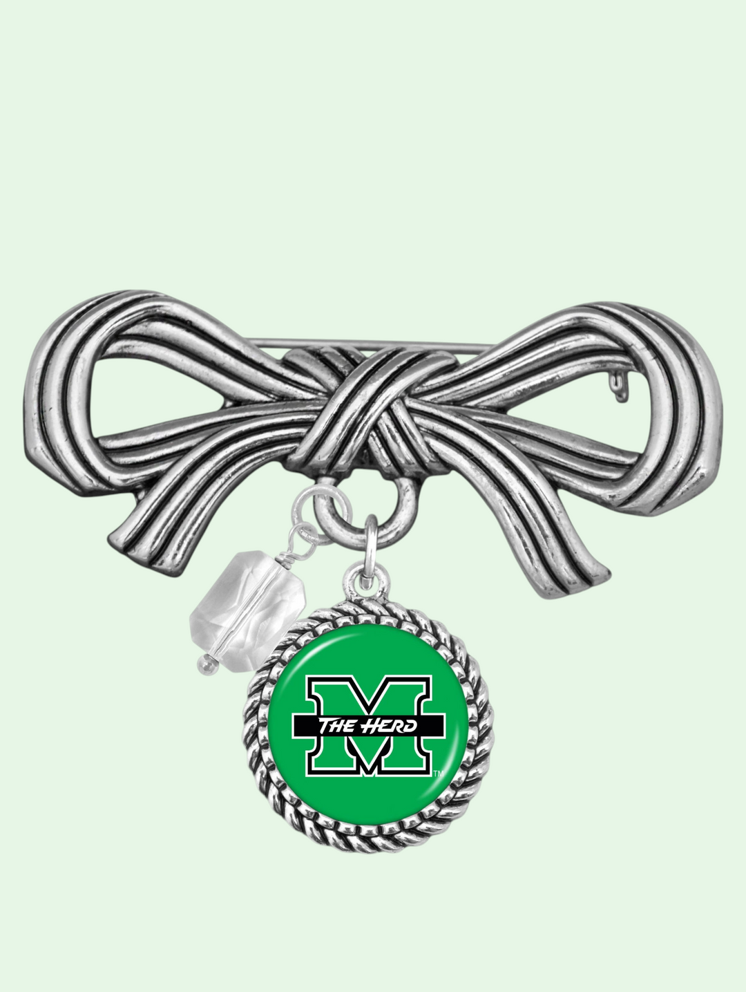 Silver bow-shaped brooch with a green circle charm featuring a logo on a light green background