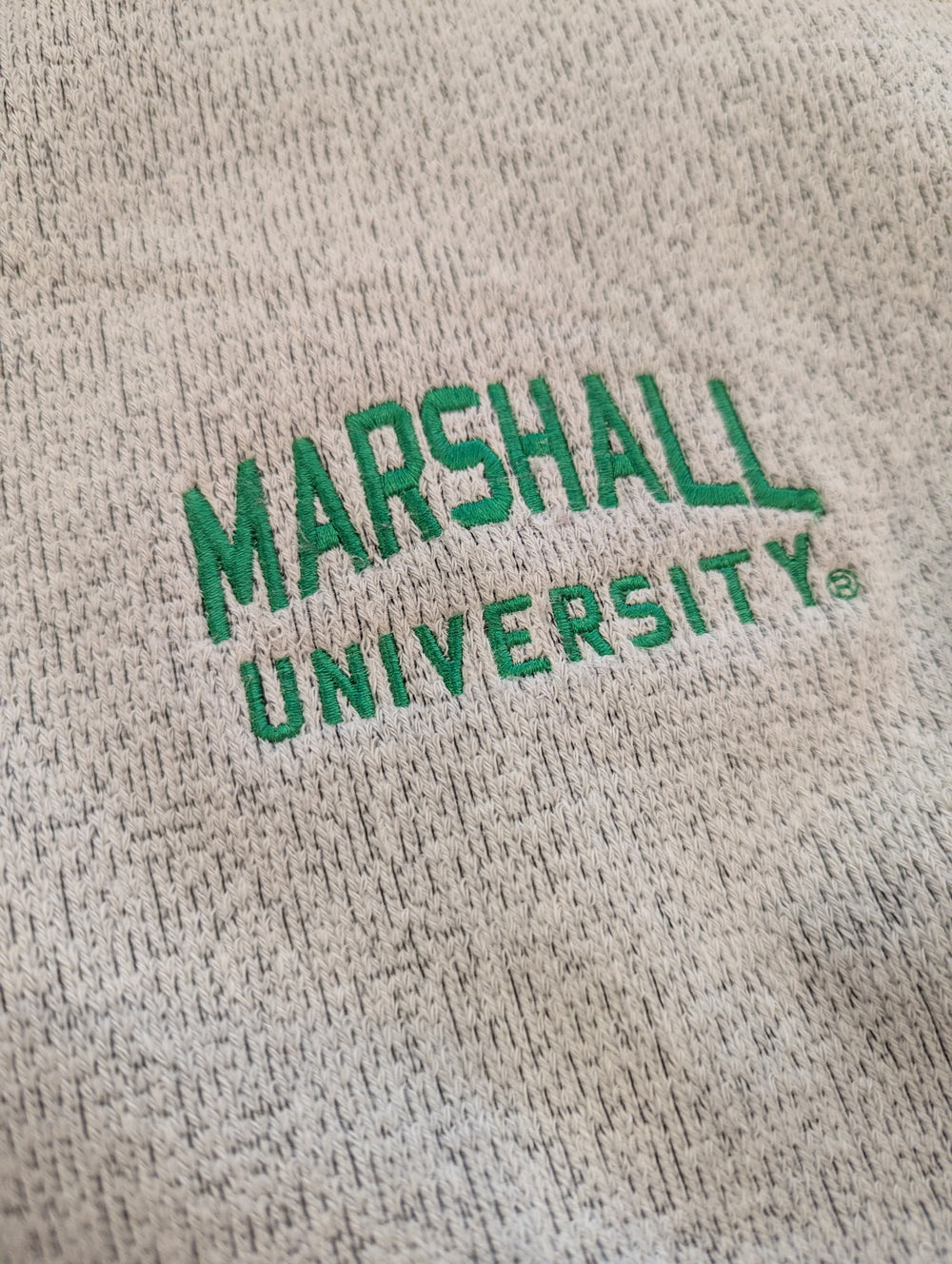 Text 'MARSHALL UNIVERSITY' embroidered on a textured beige background