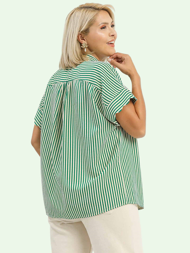Woman wearing a green and white striped shirt on a light green background
