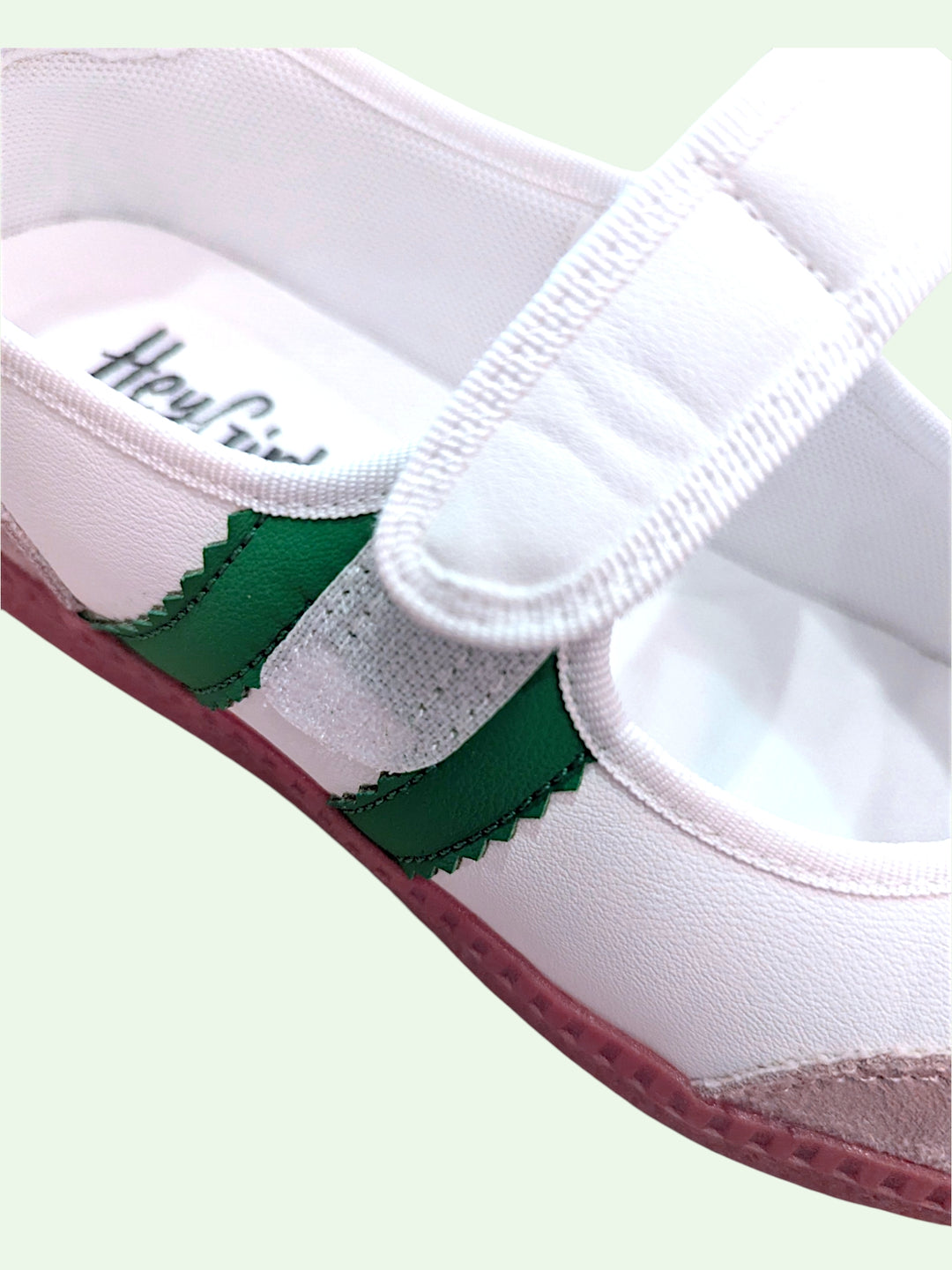 White shoe with green accents on a light green background