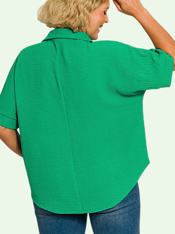 Person wearing a green blouse with a plain background