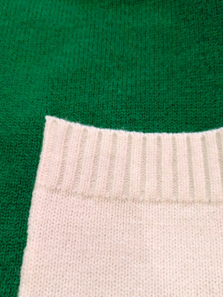 Close-up of a green fabric surface showing the white pocket