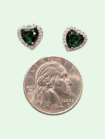 Heart-shaped green gemstone earrings next to a quarter on a light green background