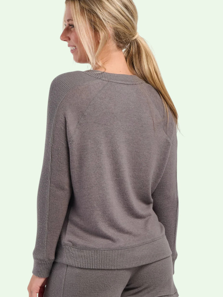 Woman wearing a gray sweater on a light green background