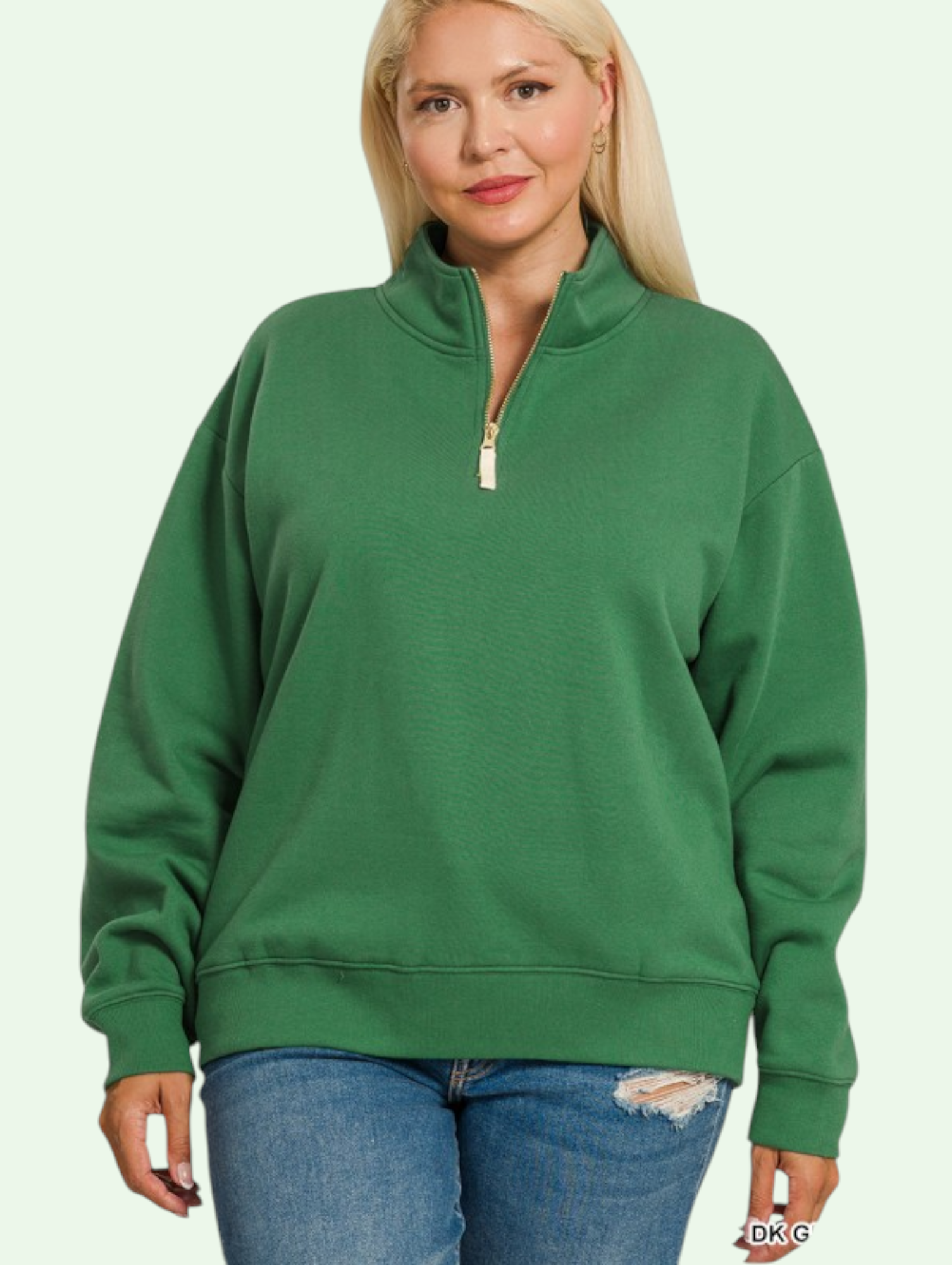Woman wearing a green sweatshirt with a quarter zip on a light green background
