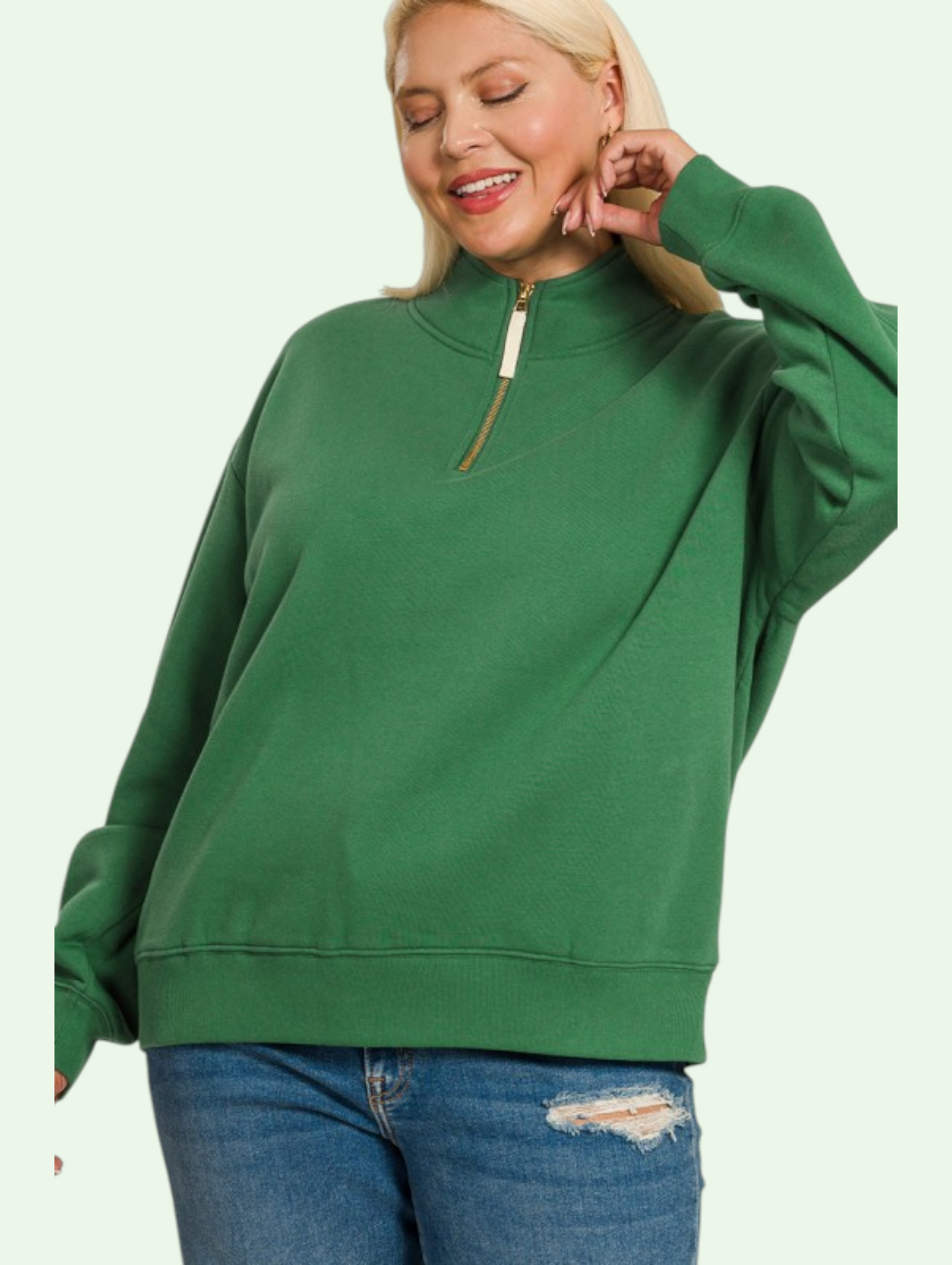Person wearing a green sweatshirt with a zipper on a light green background