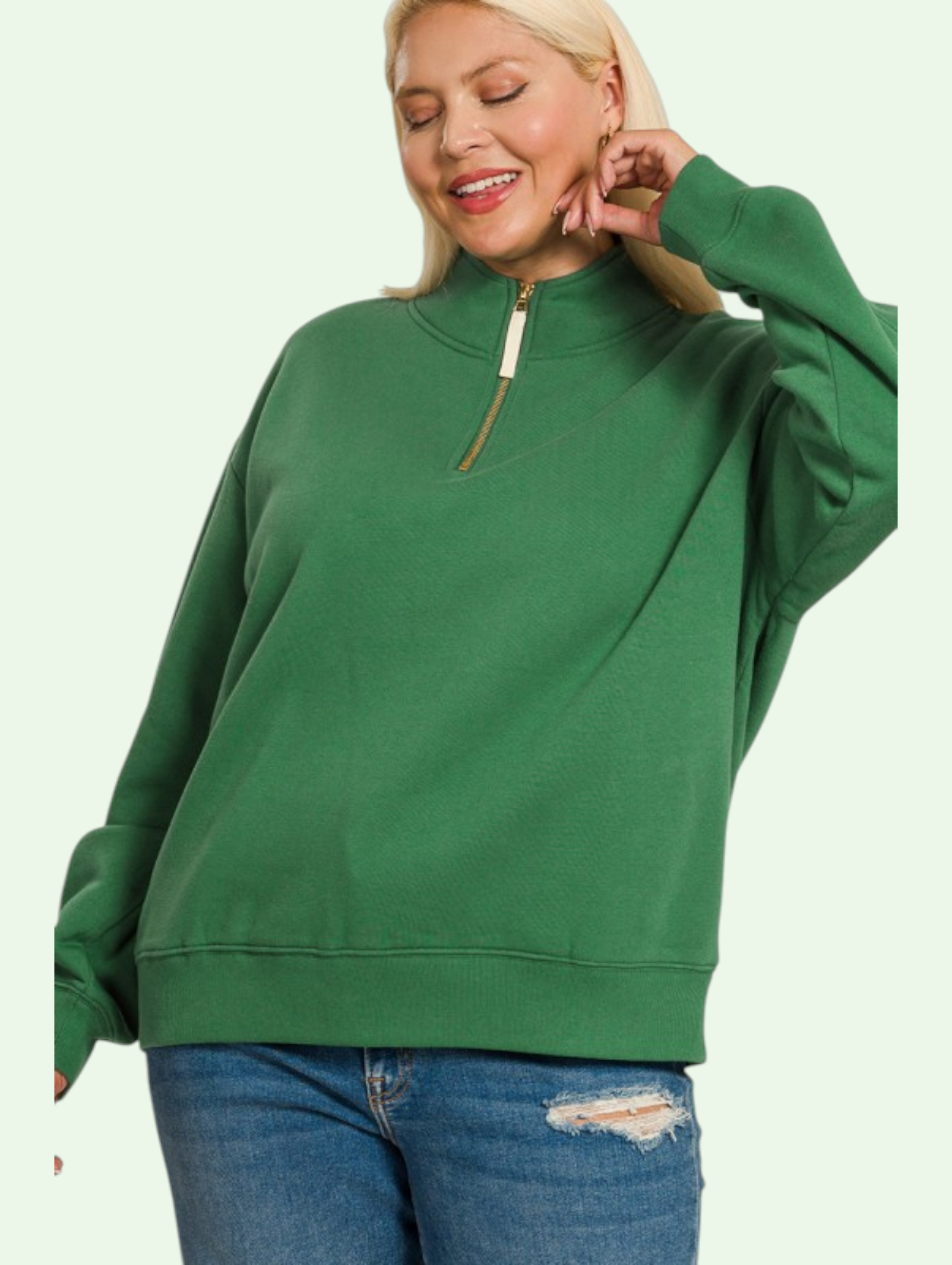 Person wearing a green sweatshirt with a zipper on a light green background
