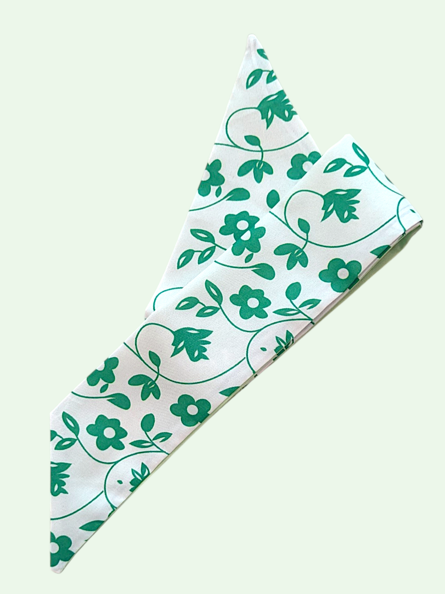 Floral patterned fabric with green flowers and leaves on a white background