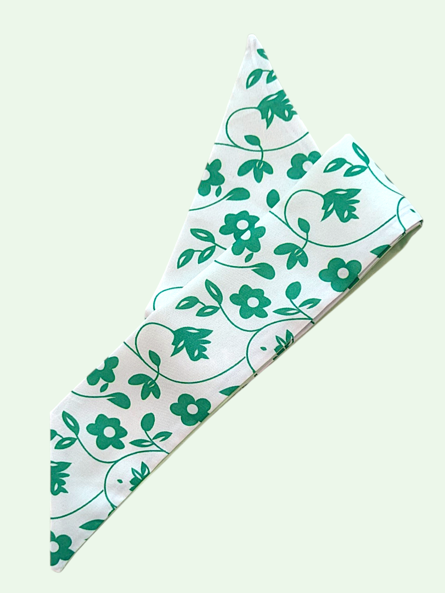 Floral patterned fabric with green flowers and leaves on a white background