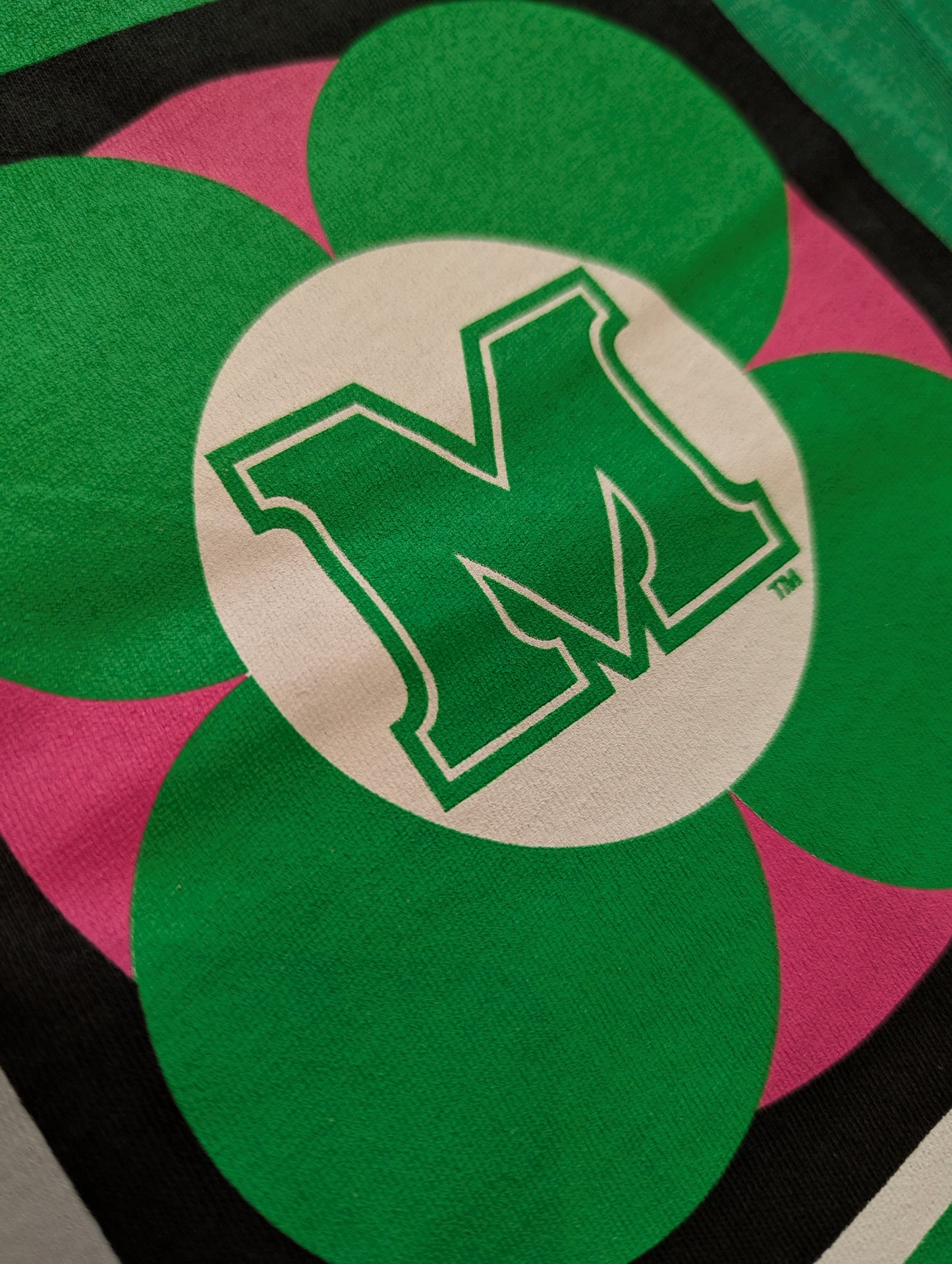 Green 'M' logo on a colorful background